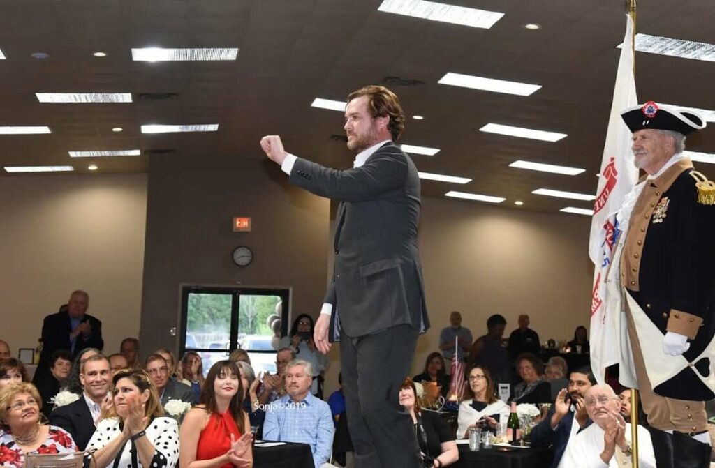 A man in a suit is speaking to an audience.
