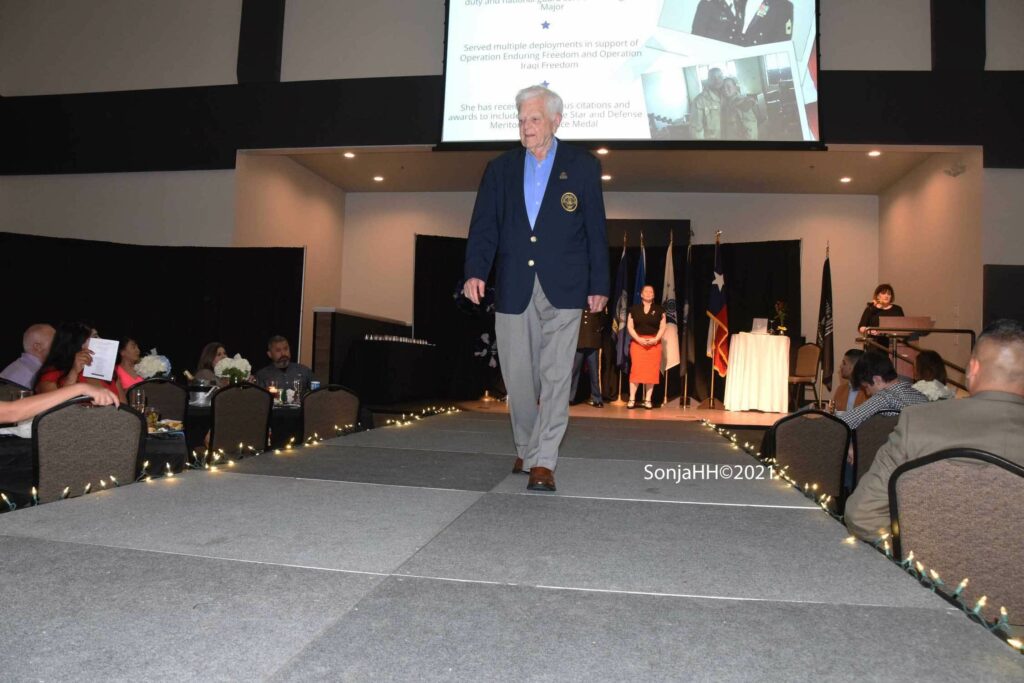 A man in a suit walks down the runway.