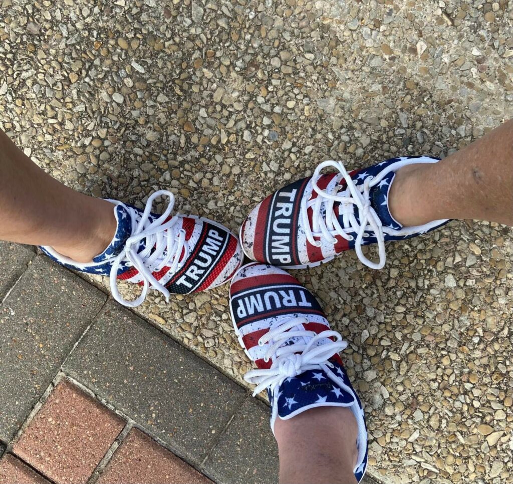 A person wearing patriotic shoes on the ground.