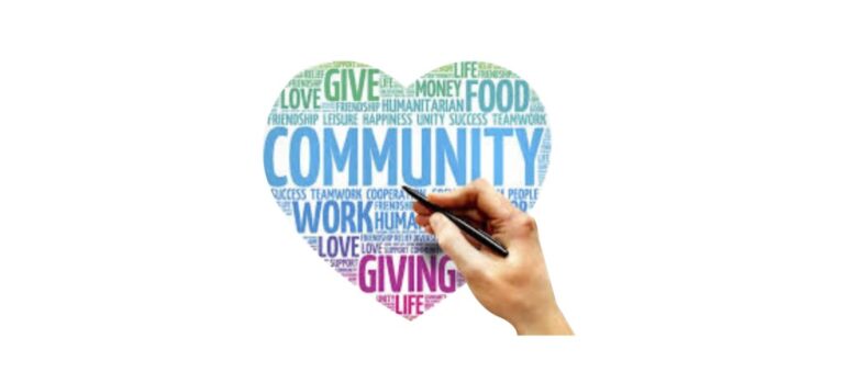 A hand writing the word community in a heart shape.