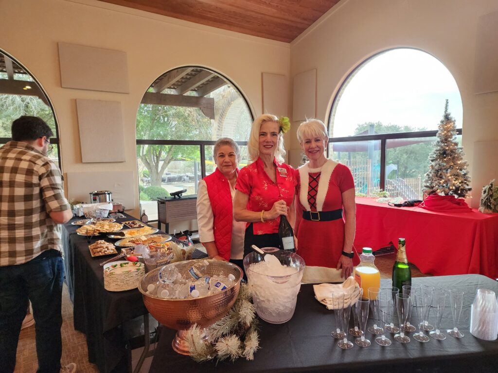 Three women standing in front of a buffet table.