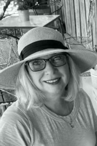 A woman wearing glasses and a hat.